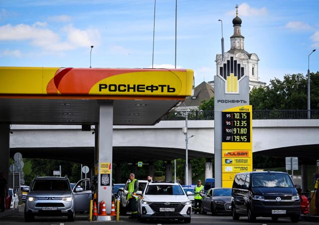 People refuel their cars at a Rosneft gas station in Moscow on June 30, 2026. Russia's largest oil giants are tightening fuel restrictions at their gas stations in Moscow and the Moscow region as the fuel crisis, engulfed virtually every region, deepens after the Kapotnya refinery in Moscow burned twice in June as a result of Ukrainian drone strikes, as well as few more refineries in Russia, and now dispensing no more than 20 liters of gasoline per vehicle. Filling canisters is prohibited, local media report. (Photo by Alexander NEMENOV / AFP)