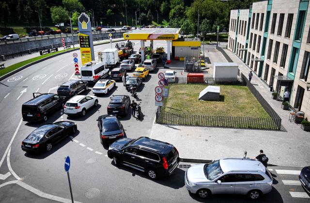 People queue to refuel their cars at a Rosneft gas station in Moscow on June 30, 2026. Russia's largest oil giants are tightening fuel restrictions at their gas stations in Moscow and the Moscow region as the fuel crisis, engulfed virtually every region, deepens after the Kapotnya refinery in Moscow burned twice in June as a result of Ukrainian drone strikes, as well as few more refineries in Russia, and now dispensing no more than 20 liters of gasoline per vehicle. Filling canisters is prohibited, local media report. (Photo by Alexander NEMENOV / AFP)