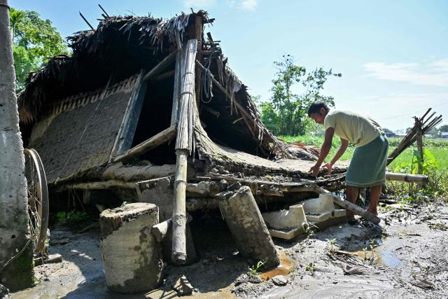 A villager looks for his belongings in his damaged house following monsoon floods in Dhemaji on June 30, 2026. (Photo by Biju BORO / AFP)
