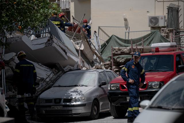 Emergency personnel search for victims amid the rubble at the site of a building collapse in the Petralona neighbourhood of Athens, on June 30, 2026. Construction work was underway on a neighboring plot of land and may have been the cause of the collapse, which occurred gradually, of a residential apartment building in Athens on June 30, 2026. (Photo by Angelos TZORTZINIS / AFP)