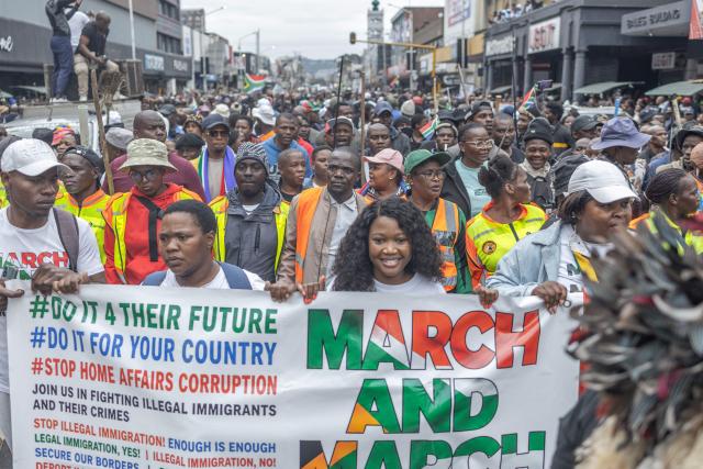 Protesters hold a banner as they march during a demonstration by the "March and March" movement marking an unofficial deadline set by citizen-led groups for undocumented foreign nationals to leave South Africa, in Durban, on June 30, 2026. Thousands of demonstrators massed across South African cities on June 30, 2026, venting anger at undocumented foreign nationals as police mounted a major operation to head off looting and xenophobic violence that has claimed four lives. 
The nationwide protests cap weeks of demonstrations called by a loose coalition of minor political parties and small citizen-led vigilante groups, which set an unofficial June 30 deadline for foreigners without residency papers to leave. (Photo by RAJESH JANTILAL / AFP)