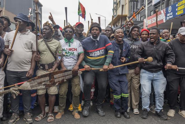 TOPSHOT - Members of the Zulu regiment known as the ‘Amabutho’ chant slogans as they march during a demonstration by the "March and March" movement marking an unofficial deadline set by citizen-led groups for undocumented foreign nationals to leave South Africa, in Durban, on June 30, 2026. Thousands of demonstrators massed across South African cities on June 30, 2026, venting anger at undocumented foreign nationals as police mounted a major operation to head off looting and xenophobic violence that has claimed four lives. 
The nationwide protests cap weeks of demonstrations called by a loose coalition of minor political parties and small citizen-led vigilante groups, which set an unofficial June 30 deadline for foreigners without residency papers to leave. (Photo by RAJESH JANTILAL / AFP)