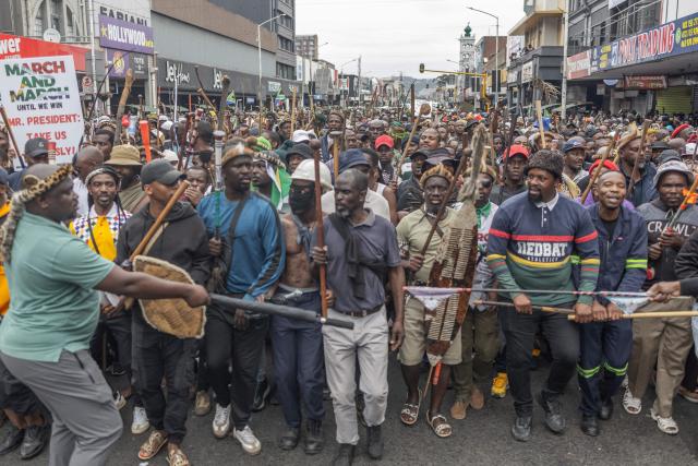 Members of the Zulu regiment known as the ‘Amabutho’ chant slogans as they march during a demonstration by the "March and March" movement marking an unofficial deadline set by citizen-led groups for undocumented foreign nationals to leave South Africa, in Durban, on June 30, 2026. Thousands of demonstrators massed across South African cities on June 30, 2026, venting anger at undocumented foreign nationals as police mounted a major operation to head off looting and xenophobic violence that has claimed four lives. 
The nationwide protests cap weeks of demonstrations called by a loose coalition of minor political parties and small citizen-led vigilante groups, which set an unofficial June 30 deadline for foreigners without residency papers to leave. (Photo by RAJESH JANTILAL / AFP)