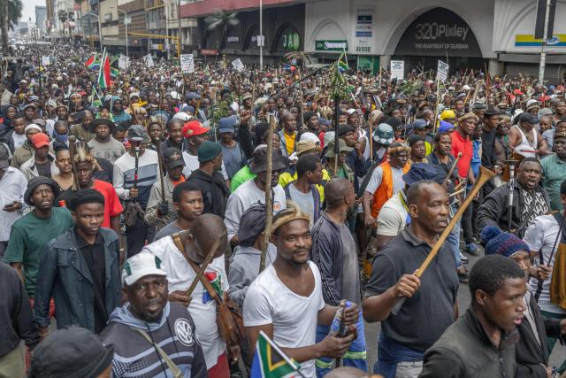 Members of the Zulu regiment known as the ‘Amabutho’ chant slogans as they march during a demonstration by the "March and March" movement marking an unofficial deadline set by citizen-led groups for undocumented foreign nationals to leave South Africa, in Durban, on June 30, 2026. Thousands of demonstrators massed across South African cities on June 30, 2026, venting anger at undocumented foreign nationals as police mounted a major operation to head off looting and xenophobic violence that has claimed four lives. 
The nationwide protests cap weeks of demonstrations called by a loose coalition of minor political parties and small citizen-led vigilante groups, which set an unofficial June 30 deadline for foreigners without residency papers to leave. (Photo by RAJESH JANTILAL / AFP)