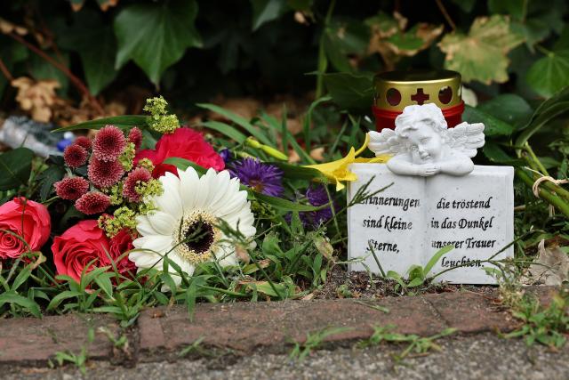Flowers are left at a makeshift memorial at the scene where six people were killed in a shooting the day before in Stade, northern Germany, a city some 50 kilometres west of Hamburg, on June 30, 2026. The suspected shooter who killed six people at a German youth welfare centre on Monday was in a custody dispute over his three-month-old daughter, police said. The victims of the shooting -- four women and two men -- were youth welfare employees, a police official told a press conference. The girl and her mother were in the office at the time of the shooting but were not harmed. (Photo by Ibrahim OT / AFP)