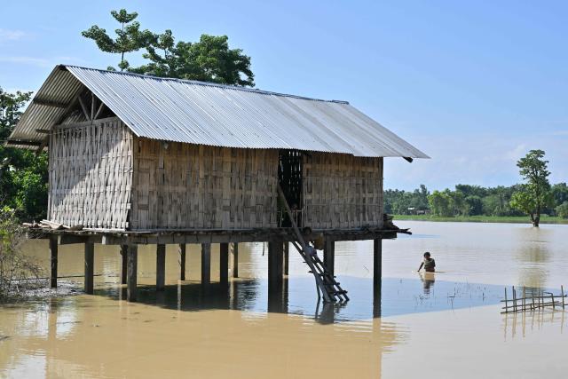 A villager wades through floodwaters in Dhemaji on June 30, 2026. (Photo by Biju BORO / AFP)