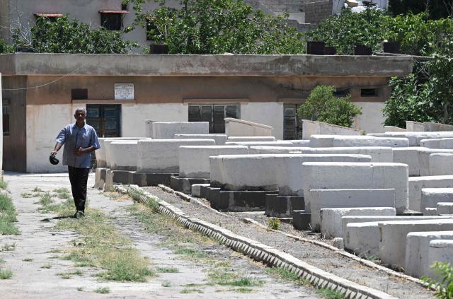 A Syrian worker walks inside the Jewish cemetery in Damascus on June 30, 2026. After the new government took power in Syria, Syrian Jews began visiting their country and cleaning their old cemeteries. (Photo by LOUAI BESHARA / AFP)