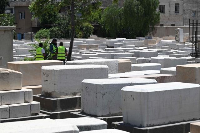 Syrian workers are seen inside the Jewish cemetery in Damascus on June 30, 2026. After the new government took power in Syria, Syrian Jews began visiting their country and cleaning their old cemeteries. (Photo by LOUAI BESHARA / AFP)