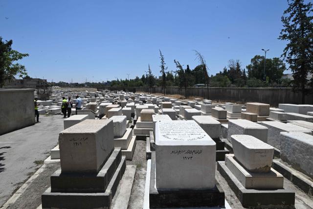 Syrian workers are seen inside the Jewish cemetery in Damascus on June 30, 2026. After the new government took power in Syria, Syrian Jews began visiting their country and cleaning their old cemeteries. (Photo by LOUAI BESHARA / AFP)