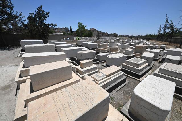 Syrian workers are seen inside the Jewish cemetery in Damascus on June 30, 2026. After the new government took power in Syria, Syrian Jews began visiting their country and cleaning their old cemeteries. (Photo by LOUAI BESHARA / AFP)