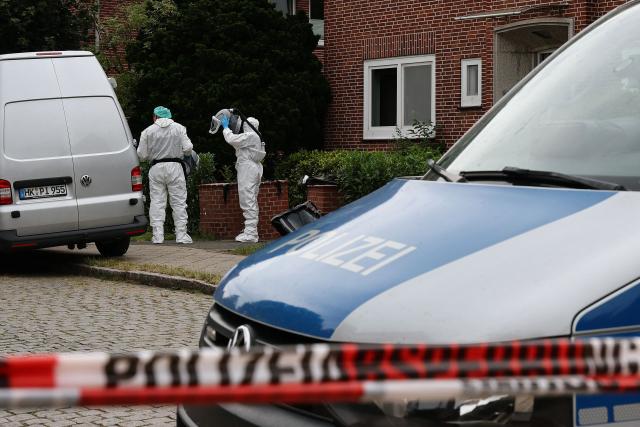 Forensic Police officers take off their breathing apparatus as they work at the scene where six people were killed in a shooting the day before in Stade, northern Germany, a city some 50 kilometres west of Hamburg, on June 30, 2026. The suspected shooter who killed six people at a German youth welfare centre on Monday was in a custody dispute over his three-month-old daughter, police said. The victims of the shooting -- four women and two men -- were youth welfare employees, a police official told a press conference. The girl and her mother were in the office at the time of the shooting but were not harmed. (Photo by Ibrahim OT / AFP)