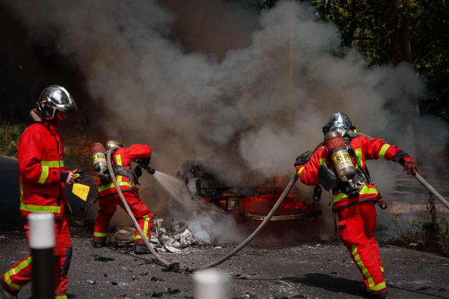 Firefighters attempt to extinguish a burning vehicle in L'ile-Saint-Denis (Saint-Denis Island), northern Paris suburb, on June 30, 2026. (Photo by Dimitar DILKOFF / AFP)