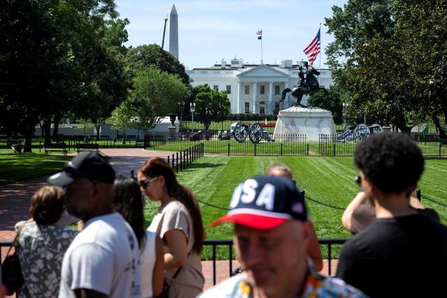 People walk past and take pictures from Lafayette Square where anti-scale fencing has been removed as workers build scaffolding around the columns of the North Portico of the White House in Washington, DC, on June 30, 2026. (Photo by Kent Nishimura / AFP)