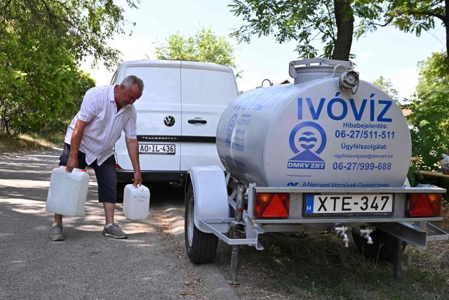 Istvan Bocsi, a 62-year-old residents of the Hungarian village of Szada, collects water from a mobile water tank in scorching 40-degree heat, 25 kilometres northwest of Budapest on June 30, 2026. Since the morning of June 29, 2026, the village of Szada has been without tap water because the network has been overwhelmed by rising demand amid Europe's most severe heatwave, which is now battering eastern parts of the continent. (Photo by Attila KISBENEDEK / AFP)