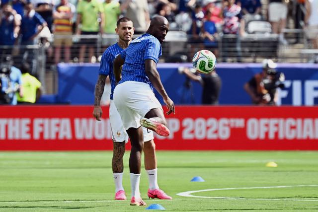 France's defender #21 Lucas Hernandez (L) and forward #22 Jean-Philippe Mateta (R) warm up ahead of the 2026 World Cup round of 32 football match between France and Sweden at the New York/New Jersey Stadium in East Rutherford on June 30, 2026.  (Photo by Jewel SAMAD / AFP)