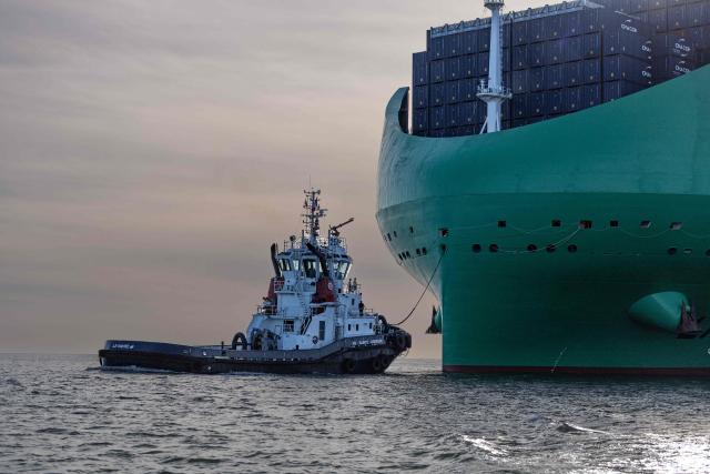 A tugboat escorts the CMA-CGM container ship the "Notre Dame", France's largest container ship, as it approaches the northern port of Le Havre on June 29, 2026. With 400 meters long, 62 meters wide, and 75 meters high, the CMA CGM Notre-Dame is designed to carry up to 24,212 containers. (Photo by ALAIN JOCARD / AFP)