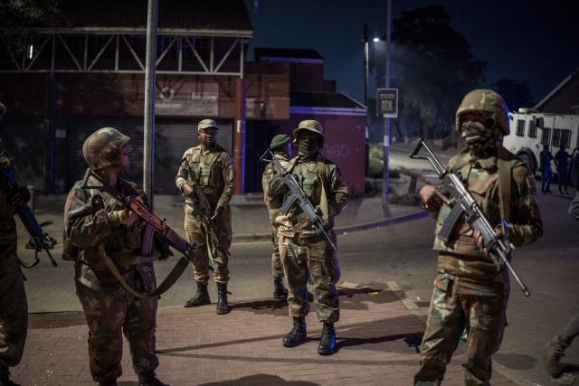 Soldiers with the South African National Defence Forces (SANDF) patrol the scene of looting in the Umlazi area of Durban, on June 30, 2026. Thousands of demonstrators massed across South African cities on June 30, 2026, venting anger at undocumented foreign nationals as police mounted a major operation to head off looting and xenophobic violence that has claimed four lives.The nationwide protests cap weeks of demonstrations called by a loose coalition of minor political parties and small citizen-led vigilante groups, which set an unofficial June 30 deadline for foreigners without residency papers to leave. (Photo by MARCO LONGARI / AFP)