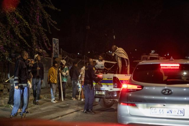 A man and a woman are loaded on the back of a police van  as officers of the South Africa National defence Forces (SANDF) and of the South Africa Police Service (SAPS) patrol the scene of looting in the Umlazi area of Durban, on June 30, 2026. Thousands of demonstrators massed across South African cities on June 30, 2026, venting anger at undocumented foreign nationals as police mounted a major operation to head off looting and xenophobic violence that has claimed four lives.The nationwide protests cap weeks of demonstrations called by a loose coalition of minor political parties and small citizen-led vigilante groups, which set an unofficial June 30 deadline for foreigners without residency papers to leave. (Photo by MARCO LONGARI / AFP)