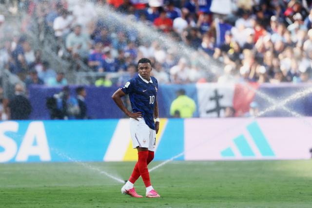 France's forward #10 Kylian Mbappe gestures as he is sprayed by the sprinklers during the 2026 World Cup round of 32 football match between France and Sweden at the New York/New Jersey Stadium in East Rutherford on June 30, 2026.  (Photo by CHARLY TRIBALLEAU / AFP)