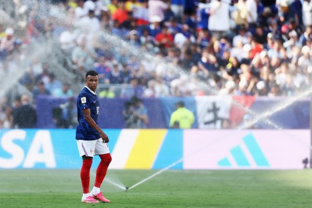 France's forward #10 Kylian Mbappe gestures as he is sprayed by the sprinklers during the 2026 World Cup round of 32 football match between France and Sweden at the New York/New Jersey Stadium in East Rutherford on June 30, 2026.  (Photo by CHARLY TRIBALLEAU / AFP)