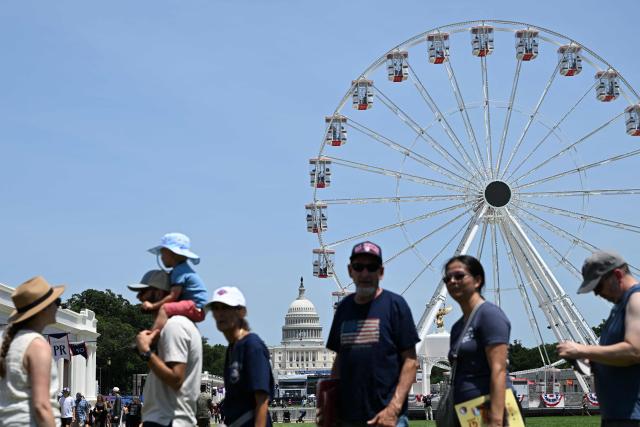 Part of the Ferris wheel and the US Capitol dome are seen in the distance as people attend the "Great American State Fair" on the National Mall in Washington, DC, on June 30, 2026. "The Great American State Fair" is an exhibition of US traditions, its people and culture to celebrate the 250th anniversary of the United States' Declaration of Independence. (Photo by Alex WROBLEWSKI / AFP)