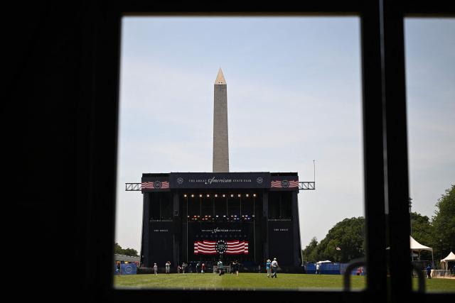 People walk on the grass during the "Great American State Fair" on the National Mall in Washington, DC, on June 30, 2026. "The Great American State Fair" is an exhibition of US traditions, its people and culture to celebrate the 250th anniversary of the United States' Declaration of Independence. (Photo by Alex WROBLEWSKI / AFP)
