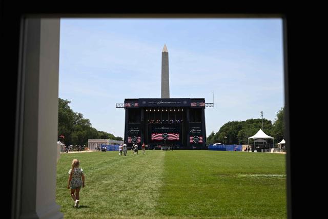 People walk on the grass during the "Great American State Fair" on the National Mall in Washington, DC, on June 30, 2026. "The Great American State Fair" is an exhibition of US traditions, its people and culture to celebrate the 250th anniversary of the United States' Declaration of Independence. (Photo by Alex WROBLEWSKI / AFP)