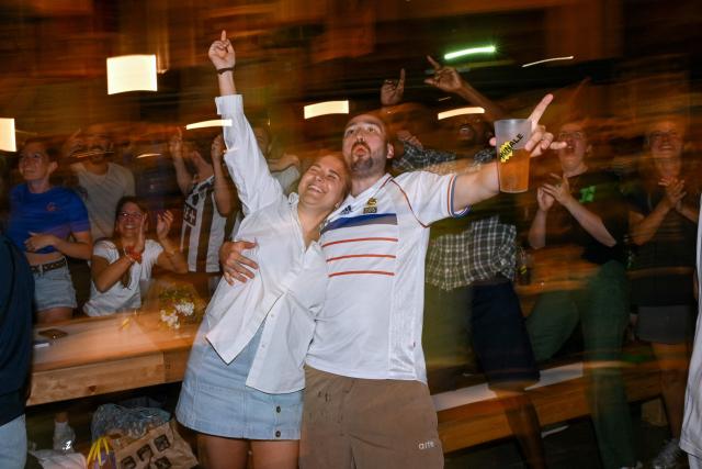 France supporters celebrate France's third goal as they watch the 2026 World Cup round of 32 football match between France and Sweden on a giant screen at 'La Communale de Saint-Ouen', in Saint-Ouen, north of Paris, on June 30, 2026. (Photo by Julie SEBADELHA / AFP)