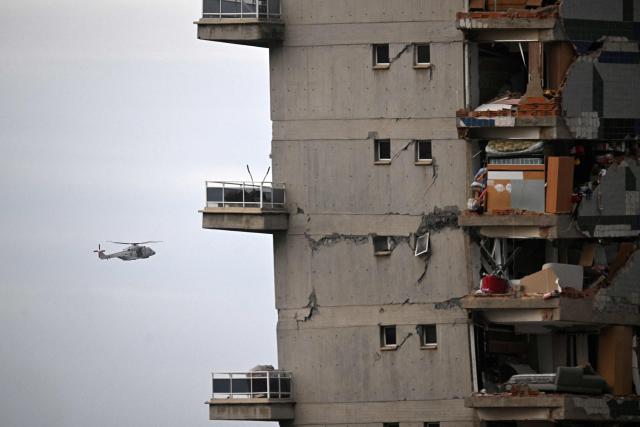 A US Marines helicopter overflies a quake-hit area in Caraballeda, La Guaira state, Venezuela, on June 30, 2026, following the June 24 twin earthquakes. Tens of thousands of people urgently need food and shelter in Venezuela due to the devastation from two huge earthquakes that killed more than 1,700 and injured 5,000, the UN said on June 30, 2026, as doctors warned of potential outbreaks of disease. (Photo by Juan BARRETO / AFP)