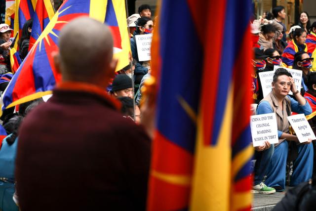 Members of the Australian Tibetan community react as they hold placards and flags during a protest in Sydney on July 1, 2026. (Photo by DAVID GRAY / AFP)
