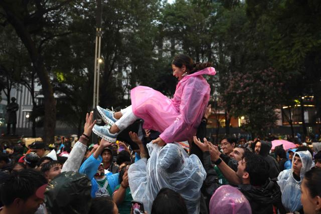 A woman is tossed into the air by Mexican fans gathering to watch the FIFA World Cup round of 32 football match between Mexico and Ecuador at the Angel of Independence in Mexico City on June 30, 2026. (Photo by Claudia Rosel / AFP)
