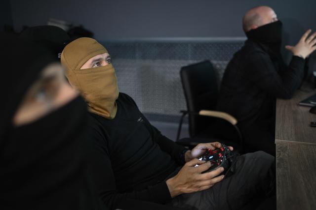 (FILES) Servicemen from the 7th Battalion of the “Madyar’s Birds” brigade operate mid-range drones from an underground control room at an undisclosed location in Ukraine, on May 15, 2026, amid the Russian invasion of Ukraine. Encrypted communications, wives and children in the dark, and being paid in envelopes of cash - the Ukrainian soldiers behind brazen long-range drone strikes on Russia live their lives almost completely in the shadows. (Photo by Genya SAVILOV / AFP)
