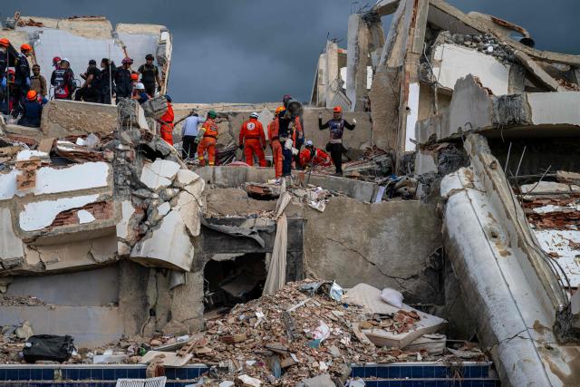 Mexican rescuers work to find survivors in the rubble of a collapsed building in Caraballeda, La Guaira state, Venezuela, on June 30, 2026, following the June 24 twin earthquakes. Tens of thousands of people urgently need food and shelter in Venezuela due to the devastation from two huge earthquakes that killed more than 1,700 and injured 5,000, the UN said on June 30, as doctors warned of potential outbreaks of disease. (Photo by Miguel MEDINA / POOL / AFP)