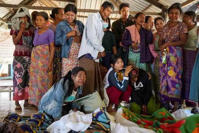 (FILES) Mourners grieve as bodies are laid out at a cemetery before their burial following a Myanmar military air strike at a hospital that killed more than 30 people in Mrauk U in western Rakhine state on December 11, 2025. More than 100,000 people have been killed across all sides in Myanmar since a military coup five years ago triggered civil war, a conflict monitor said July 1, 2026. (Photo by AFP)