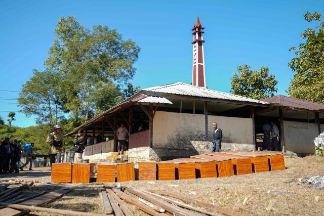 (FILES) Coffins are prepared at a cemetery for victims of a Myanmar military air strike at a hospital that killed more than 30 people in Mrauk U in western Rakhine state on December 11, 2025. More than 100,000 people have been killed across all sides in Myanmar since a military coup five years ago triggered civil war, a conflict monitor said July 1, 2026. (Photo by AFP)