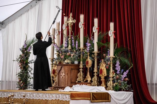 A seminarian lights the altar candles prior to the schismatic consecration of bishops by the traditionalist Catholic Society of Saint Pius X (SSPX) in Econe, western Switzerland on July 1, 2026. On June 30, 2026, Pope Leo XIV urged the Society to abandon its plan to ordain bishops without Vatican approval, warning it would lead to automatic excommunication. Founded in 1970 in Econe by French bishop Marcel Lefebvre, the Society of Saint Pius X categorically rejects the changes in the Church since the Second Vatican Council. (Photo by Fabrice COFFRINI / AFP)