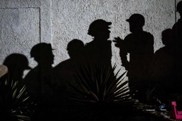This photograph shows shadows of volunteers rescuers appearing during an operation by US rescuers to find survivors in Catia la Mar in La Guaira state, Venezuela, on June 30, 2026. Tens of thousands of people urgently need food and shelter in Venezuela due to the devastation from two huge earthquakes that killed more than 1,700 and injured 5,000, the UN said on June 30, 2026, as doctors warned of potential outbreaks of disease. (Photo by Miguel MEDINA / AFP)