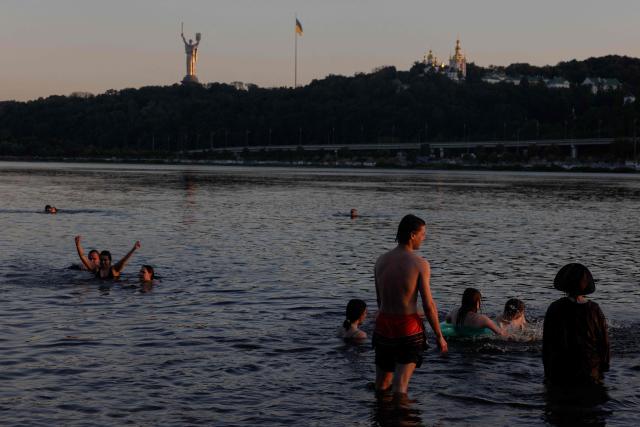 People sunbath and swim in the Dnipro River during a hot summer’s day in Kyiv on June 30, 2026, amid the Russian invasion of Ukraine. (Photo by Tetiana DZHAFAROVA / AFP)