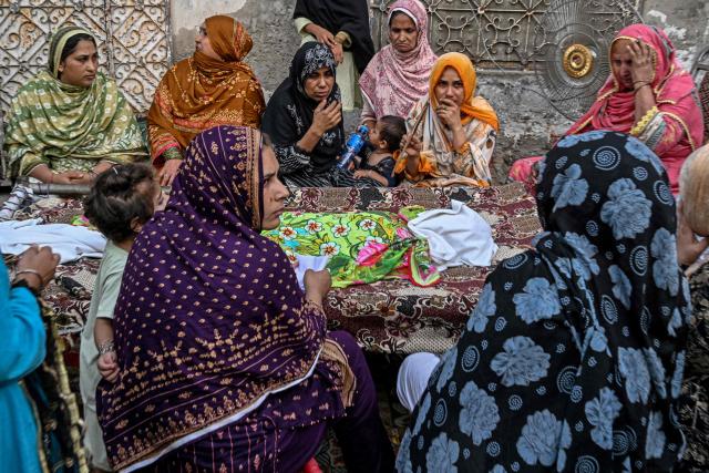 Relatives gather around the body of a deceased child before burial in Lahore on July 1, 2026, after the roof of a tutoring centre collapsed the previous day. A roof collapse at a tutoring centre in the eastern Pakistani city of Lahore killed at least 14 children and injured five on June 30, officials said. (Photo by Arif ALI / AFP)