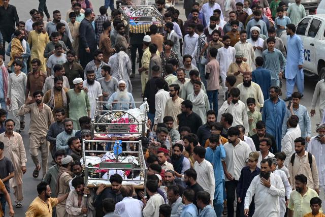 Relatives and local residents carry the bodies of deceased children for their funeral in Lahore on July 1, 2026, after the roof of a tutoring centre collapsed the previous day. A roof collapse at a tutoring centre in the eastern Pakistani city of Lahore killed at least 14 children and injured five on June 30, officials said. (Photo by Arif ALI / AFP)