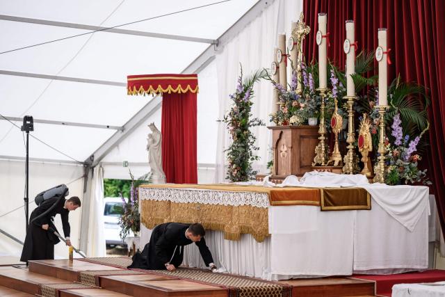 Seminarians clean the altar prior to the schismatic consecration of bishops by the traditionalist Catholic Society of Saint Pius X (SSPX) in Econe, western Switzerland, on July 1, 2026. On June 30, 2026, Pope Leo XIV urged the Society to abandon its plan to ordain bishops without Vatican approval, warning it would lead to automatic excommunication. Founded in 1970 in Econe by French bishop Marcel Lefebvre, the Society of Saint Pius X categorically rejects the changes in the Church since the Second Vatican Council. (Photo by Fabrice COFFRINI / AFP)
