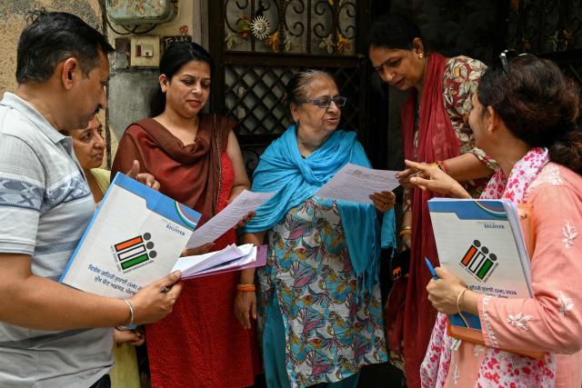 Booth Level Officials (BLO) distribute enumeration forms as part of the Election Commission of India's Special Intensive Revision (SIR), verifying voters in Amritsar on July 1, 2026. (Photo by Narinder NANU / AFP)