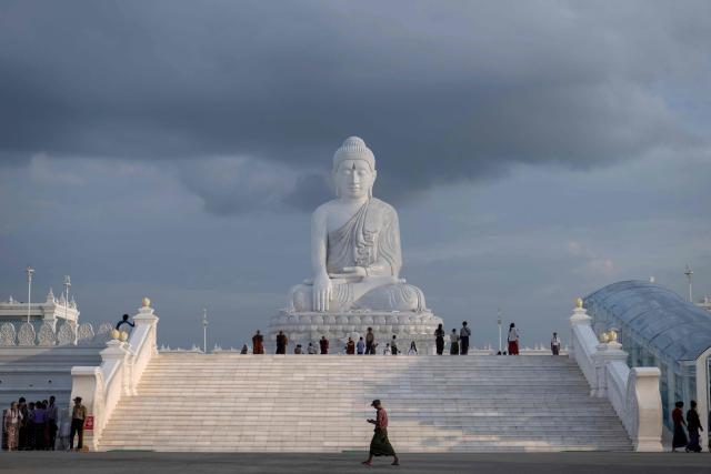 This photo taken on June 1, 2026 shows people visiting the marble Maravijaya Buddha statue in Naypyidaw. (Photo by Sai Aung MAIN / AFP)