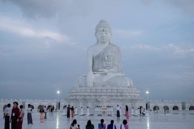 This photo taken on June 1, 2026 shows people visiting the marble Maravijaya Buddha statue in Naypyidaw. (Photo by Sai Aung MAIN / AFP)