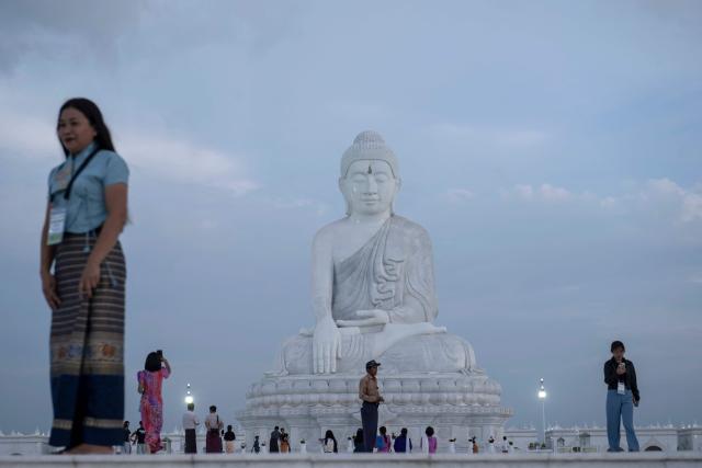 This photo taken on June 1, 2026 shows people visiting the marble Maravijaya Buddha statue in Naypyidaw. (Photo by Sai Aung MAIN / AFP)