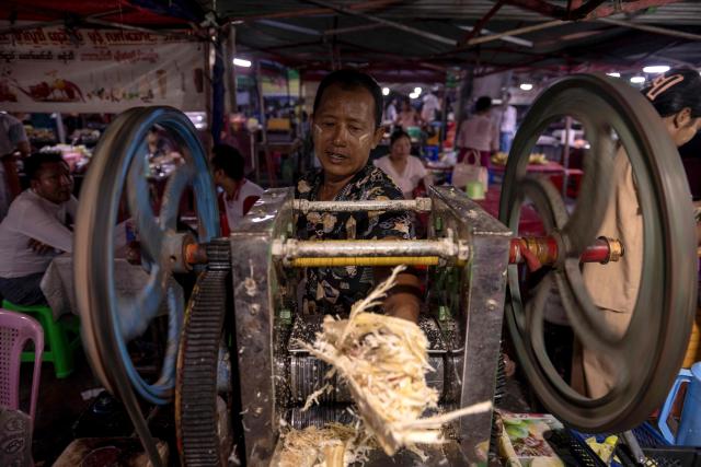 This photo taken on June 1, 2026 shows a vendor making fresh sugar cane juice at a night market in Naypyidaw. (Photo by Sai Aung MAIN / AFP)