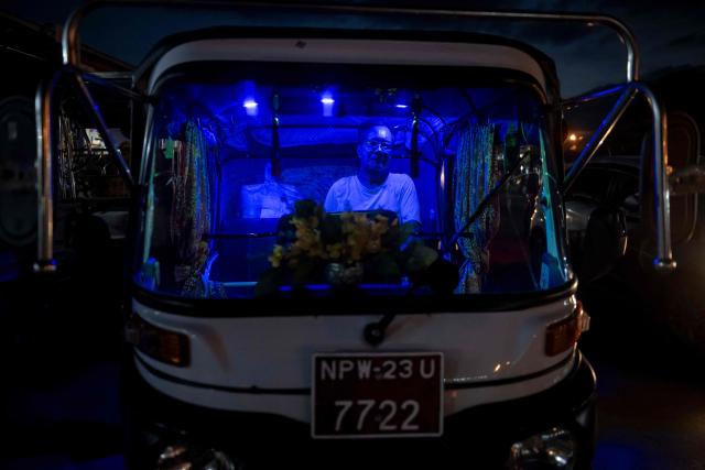 This photo taken on June 1, 2026 shows tuktuk driver waiting for passengers at a night market in Naypyidaw. (Photo by Sai Aung MAIN / AFP)