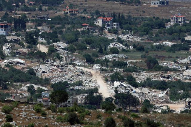 This picture taken from a position in the Upper Galilee in northern Israel shows destroyed buildings in a Lebanese village along the Israel-Lebanon border, on July 1, 2026. Israel's defence minister said on July 1 that Israeli forces would remain in self-proclaimed "security zones" established in Lebanon, Syria and Gaza, without any timeline for withdrawal. (Photo by Jack GUEZ / AFP) / 