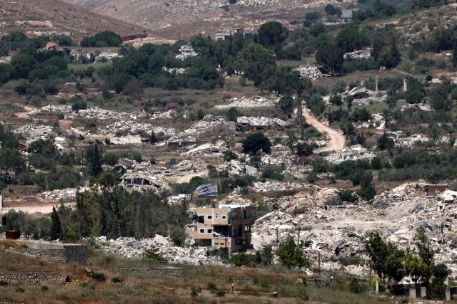This picture taken from a position in the Upper Galilee in northern Israel shows destroyed buildings in a Lebanese village along the Israel-Lebanon border, on July 1, 2026. Israel's defence minister said on July 1 that Israeli forces would remain in self-proclaimed "security zones" established in Lebanon, Syria and Gaza, without any timeline for withdrawal. (Photo by Jack GUEZ / AFP) / 