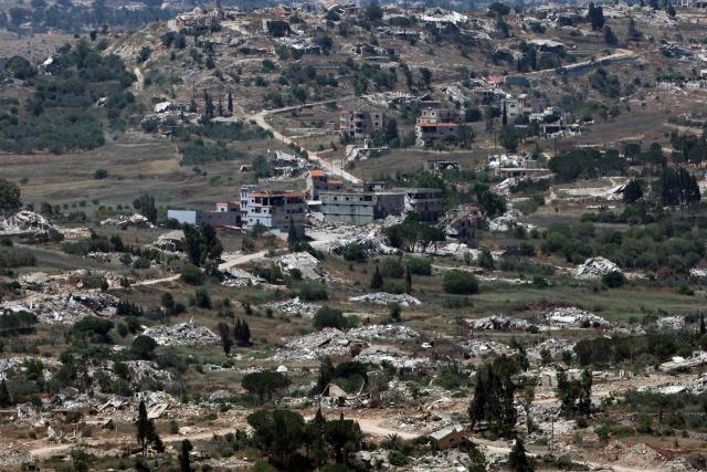 This picture taken from a position in the Upper Galilee in northern Israel shows destroyed buildings in a Lebanese village along the Israel-Lebanon border, on July 1, 2026. Israel's defence minister said on July 1 that Israeli forces would remain in self-proclaimed "security zones" established in Lebanon, Syria and Gaza, without any timeline for withdrawal. (Photo by Jack GUEZ / AFP) / 